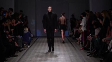 Moda gösterisi. Erkek manken podyumda yürüyor..