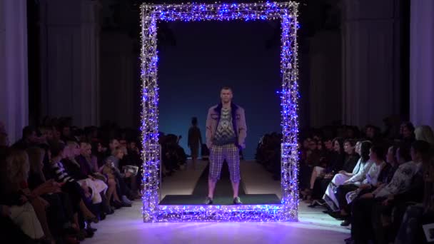 Muotinäytös. Mies mies malli kävelee catwalk. — kuvapankkivideo