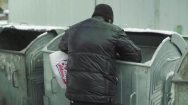 Dilenci evsiz bir serseri çöp tenekesinde yiyecek arıyor. Kyiv. Ukrayna