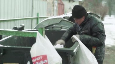 Dilenci evsiz bir serseri çöp tenekesinde yiyecek arıyor. Kyiv. Ukrayna