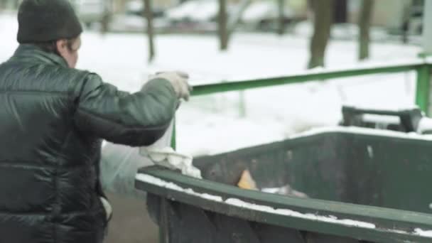 En hemlös tiggare letar efter mat i en soptunna. Kiev. Ukraina — Stockvideo