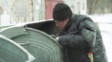 Dilenci evsiz bir serseri çöp tenekesinde yiyecek arıyor. Kyiv. Ukrayna