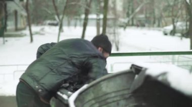 Dilenci evsiz bir serseri çöp tenekesinde yiyecek arıyor. Kyiv. Ukrayna
