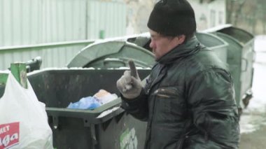 Dilenci evsiz bir serseri çöp tenekesinde yiyecek arıyor. Kyiv. Ukrayna