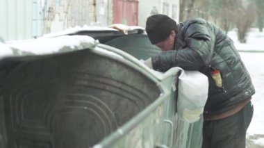 Dilenci evsiz bir serseri çöp tenekesinde yiyecek arıyor. Kyiv. Ukrayna