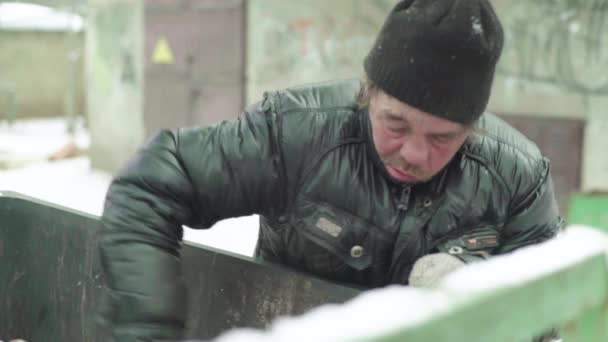 A beggar homeless man tramp is looking for food in a trash can. Kyiv. Ukraine — Stock Video