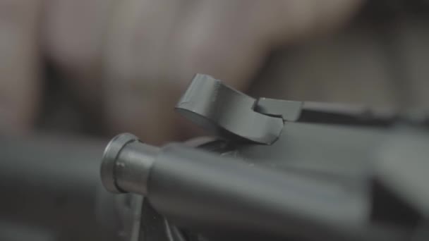 Fusil dans les mains d'un tireur pendant le tir. Au ralenti. Gros plan.