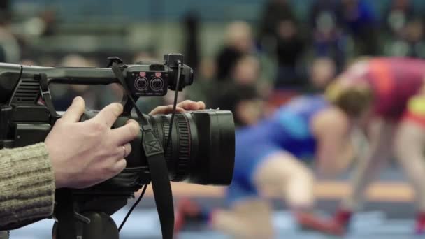 Cameraman met een camera in worstelwedstrijden. Close-up. — Stockvideo