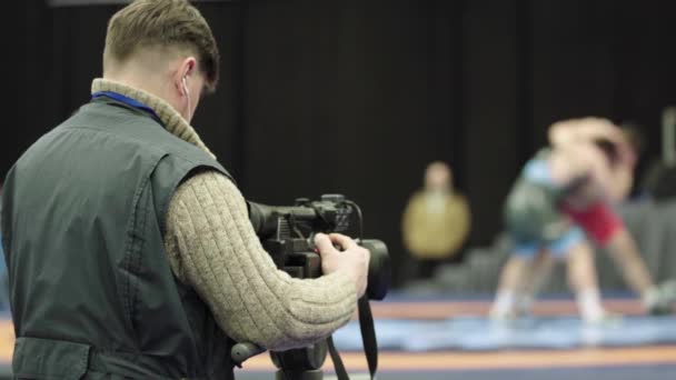 Cameraman with a camera in wrestling competitions. Close-up. — Stock Video