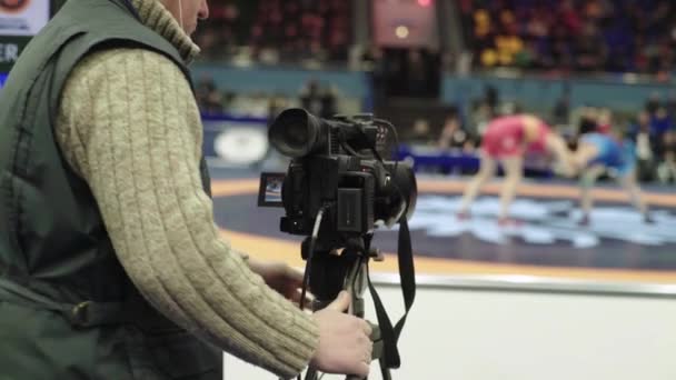 Cameraman met een camera in worstelwedstrijden. Close-up. — Stockvideo