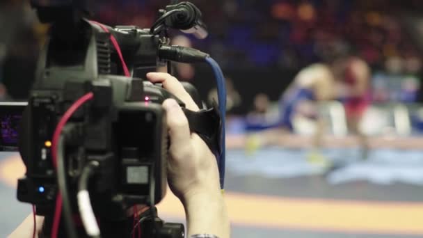 Cameraman met een camera in worstelwedstrijden. Close-up. — Stockvideo