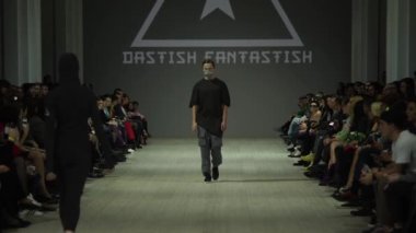 Moda gösterisi. Erkek manken podyumda yürüyor..