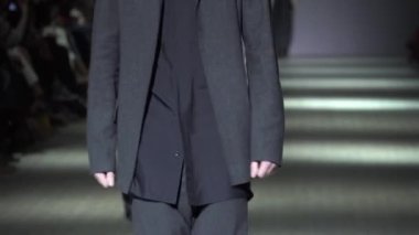 Moda gösterisi. Erkek manken podyumda yürüyor..