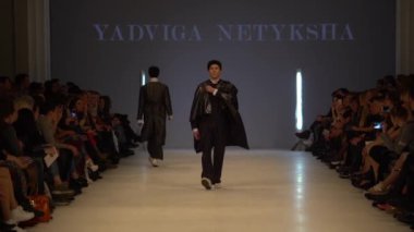 Moda gösterisi. Erkek manken podyumda yürüyor..