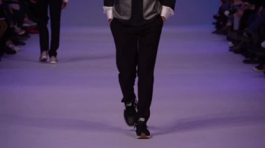 Moda gösterisi. Erkek manken podyumda yürüyor..