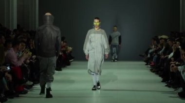 Moda gösterisi. Erkek manken podyumda yürüyor..