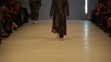 Moda gösterisi. Erkek manken podyumda yürüyor..