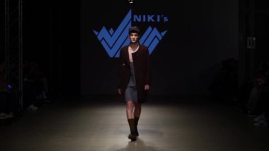 Moda gösterisi. Erkek manken podyumda yürüyor..