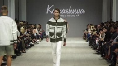 Moda gösterisi. Erkek manken podyumda yürüyor..