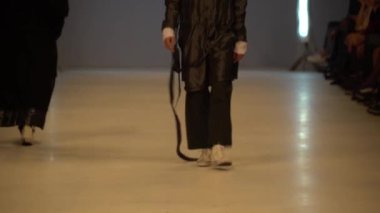 Moda gösterisi. Erkek manken podyumda yürüyor..