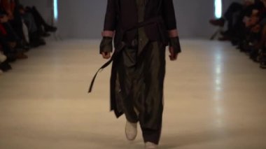 Moda gösterisi. Erkek manken podyumda yürüyor..