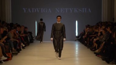 Moda gösterisi. Erkek manken podyumda yürüyor..