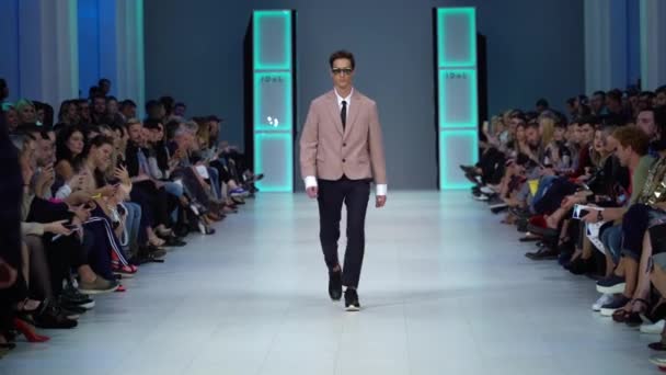 Desfile de moda. masculino homem modelo caminha no o passarela. — Vídeo de Stock