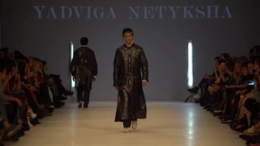 Moda gösterisi. Erkek manken podyumda yürüyor..
