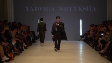 Moda gösterisi. Erkek manken podyumda yürüyor..