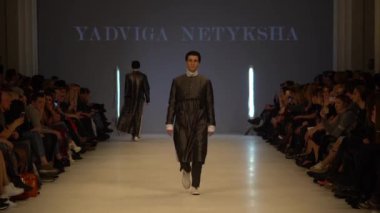 Moda gösterisi. Erkek manken podyumda yürüyor..