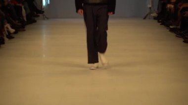 Moda gösterisi. Erkek manken podyumda yürüyor..