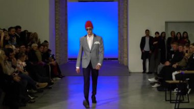 Moda gösterisi. Erkek manken podyumda yürüyor..