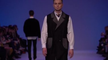 Moda gösterisi. Erkek manken podyumda yürüyor..