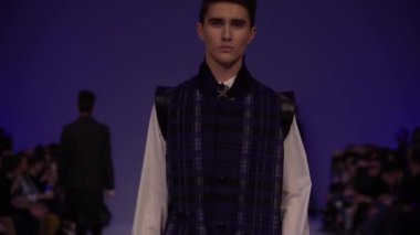 Moda gösterisi. Erkek manken podyumda yürüyor..