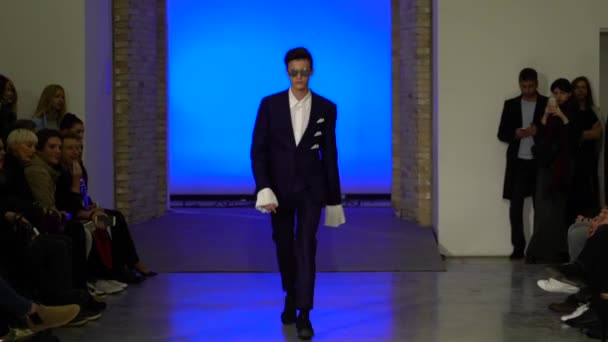 Muotinäytös. Mies mies malli kävelee catwalk. — kuvapankkivideo