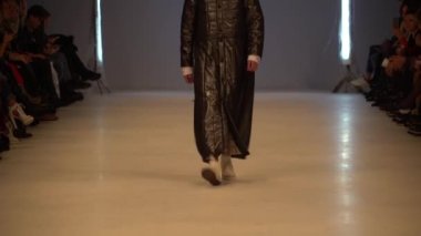 Moda gösterisi. Erkek manken podyumda yürüyor..