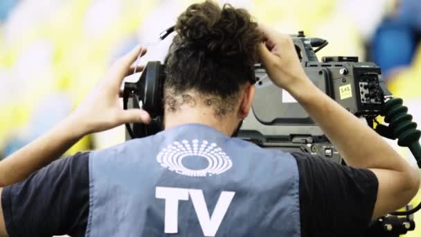 Cameraman with a camera in the stadium during a football match. TV — Stock Video