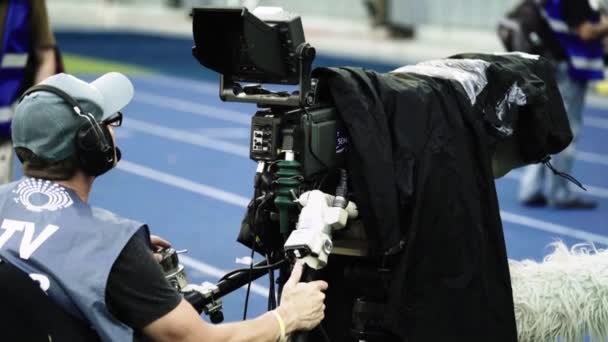 Operatőr egy kamerával a stadionban egy focimeccs alatt. TV — Stock videók
