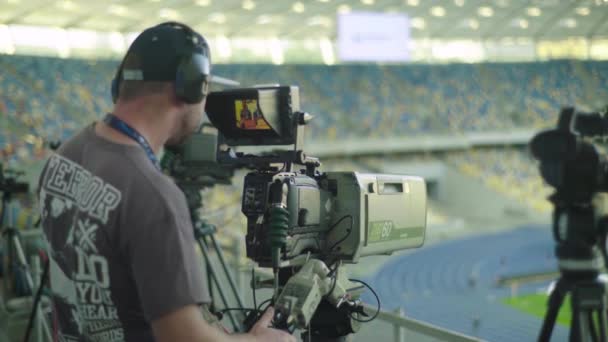 Cameraman con una telecamera nello stadio durante una partita di calcio. Televisore — Video Stock