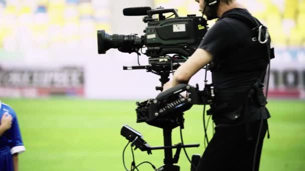 Camarógrafo con una cámara en el estadio durante un partido de fútbol. Televisión — Vídeos de Stock