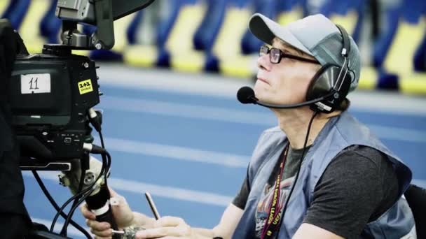 Cameraman with a camera in the stadium during a football match. TV — Stock Video