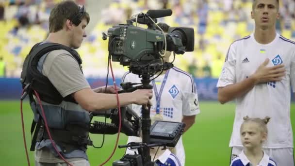 Cameraman with a camera in the stadium during a football match. TV — Stock Video