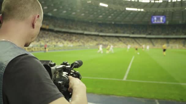 Kamerzysta z kamerą na stadionie podczas meczu piłki nożnej. Telewizja — Wideo stockowe