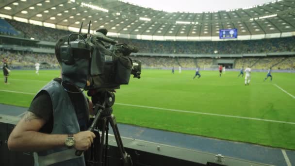 Camarógrafo con una cámara en el estadio durante un partido de fútbol. Televisión — Vídeos de Stock