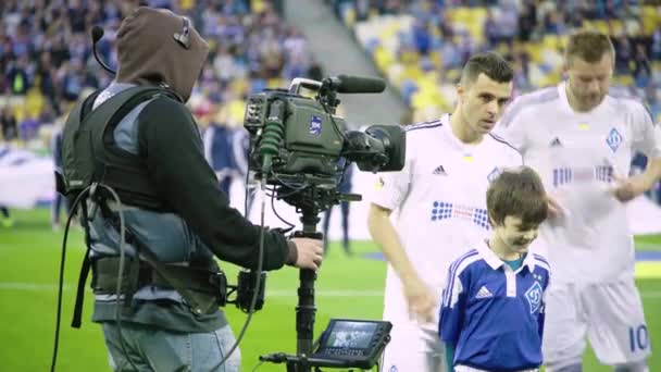 Cameraman with a camera in the stadium during a football match. TV — Stock Video