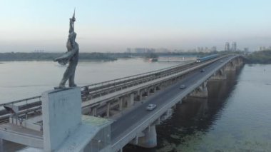 Metro Köprüsü 'nün havadan görünüşü ve metro istasyonu Dnipro' yu süsleyen iki heykel. Kyiv, Ukrayna.