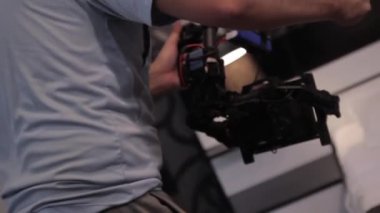 Kameraman elinde kamerayla çekim yapıyor.