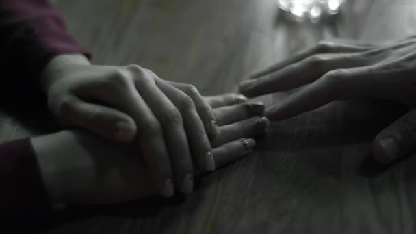 Το αρσενικό χέρι αγγίζει το θηλυκό χέρι σε μια ημερομηνία. Κοντινό πλάνο. Αργή κίνηση — Αρχείο Βίντεο