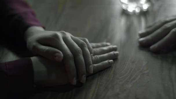 Το αρσενικό χέρι αγγίζει το θηλυκό χέρι σε μια ημερομηνία. Κοντινό πλάνο. Αργή κίνηση — Αρχείο Βίντεο