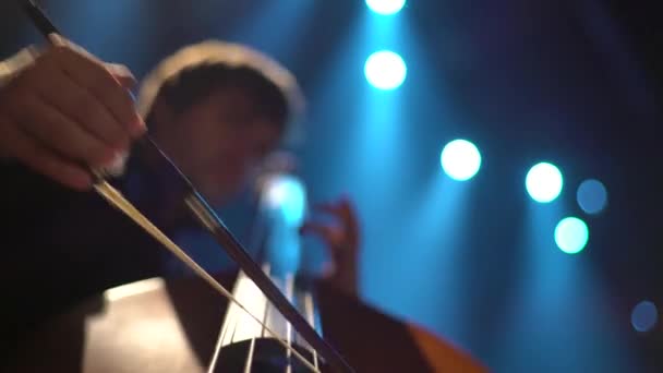 Hombre violonchelista tocando el violonchelo en el escenario en la oscuridad. Kiev. Ucrania — Vídeo de stock